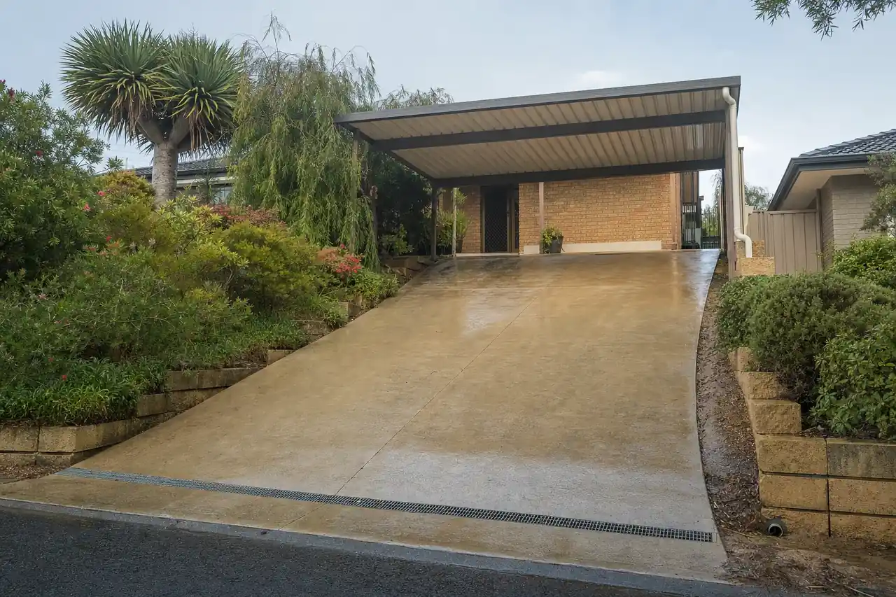 Sloping Perth driveway with a slot drain at the street end and a carport downpipe connected to stormwater